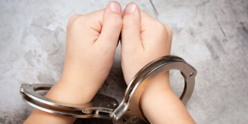 Picture of young child's hands in hand cuffs
