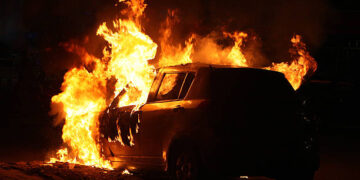 a car on fire at the roadside of Indian capital Delhi
