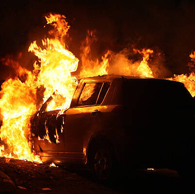 a car on fire at the roadside of Indian capital Delhi