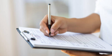 Holding clipboard and a pen in office