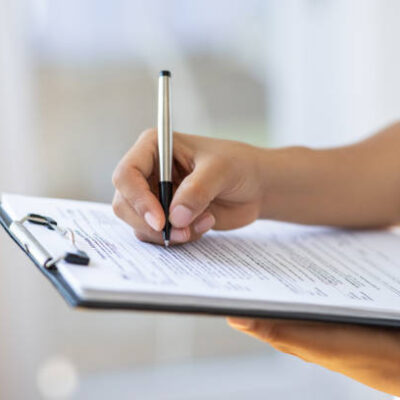 Holding clipboard and a pen in office
