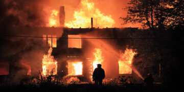 two silhouette on housefire background