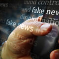 Social media on display with fake news and hoax information. Searching on tablet, pad, phone or smartphone screen in hand. Abstract concept of news titles broadcasting 3d illustration.