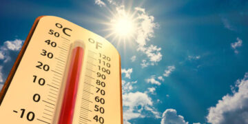 climate change, low angle view Thermometer on blue sky with sun shining in summer show increase temperature, concept global warming