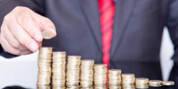 Close-up Of Businessman Stacking Coins