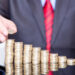 Close-up Of Businessman Stacking Coins