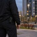 Мужчина с закрытой кобурой во дворе жилого дома — иллюстративное изображение