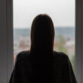 teenager anxiety,young woman is standing at the window, depression and frustration, an unhappy, sad girl