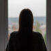 teenager anxiety,young woman is standing at the window, depression and frustration, an unhappy, sad girl