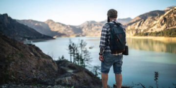 Hiking in the mountains. Tourist exploring lake in mountains