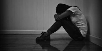 Woman sitting strain unhappy In a dark room white and black