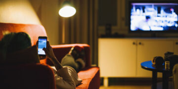 Young woman relaxing with smartphone on sofa