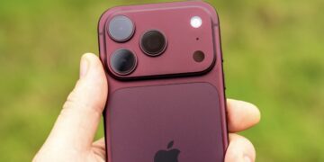 Смартфон iPhone в бордовом корпусе в руке