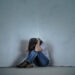 upset girl sitting in the corner of the room