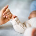 Close-up of mother's hand holding newborn baby's hand