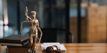 Statue of lady justice on desk of a judge or lawyer.