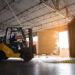 Warehouse worker driver in uniform delivery and loading pallet product by forklift.
