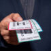 A man is engaged in ticket scalping, selling concert tickets at a significantly higher price than face value