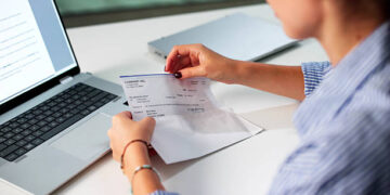 Woman In Office Managing Payroll Compensation Check Envelope With Care.