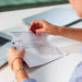 Woman In Office Managing Payroll Compensation Check Envelope With Care.