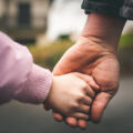 Father and child holding hands