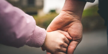 Father and child holding hands