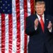 Дональд Трамп выступает на фоне флагов США